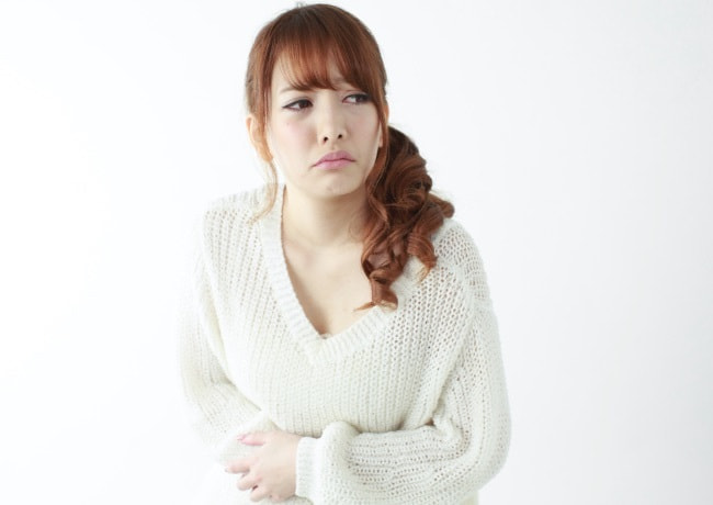 便秘や下痢等の痛みに悩む女性の画像